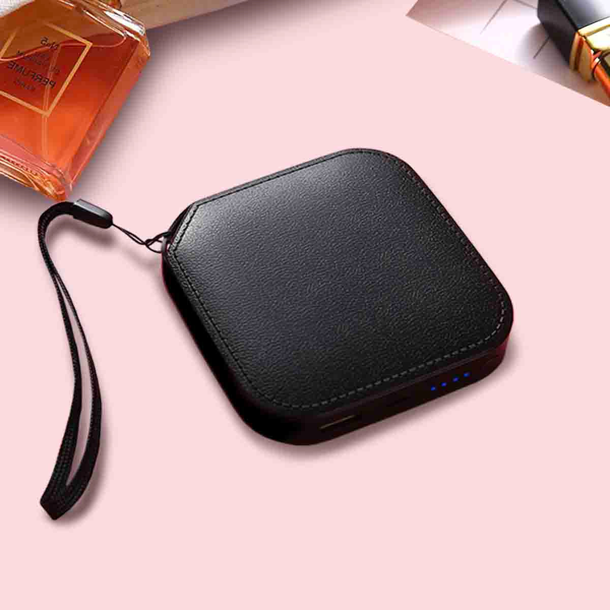 Black power bank with a strap on a pink surface